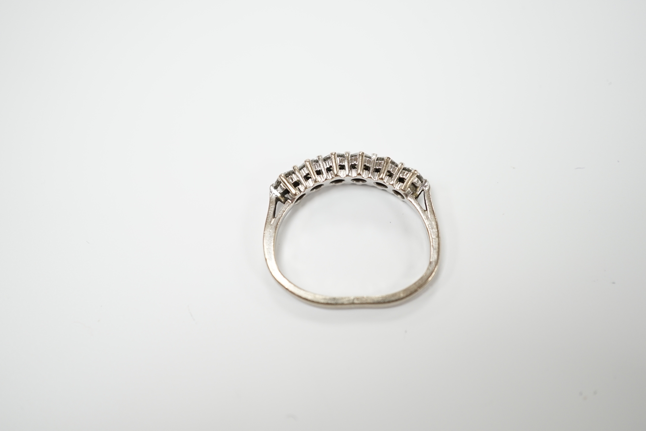 A modern 18ct white gold and six stone diamond set half hoop ring, (shank slightly crushed), gross weight 3.4 grams.